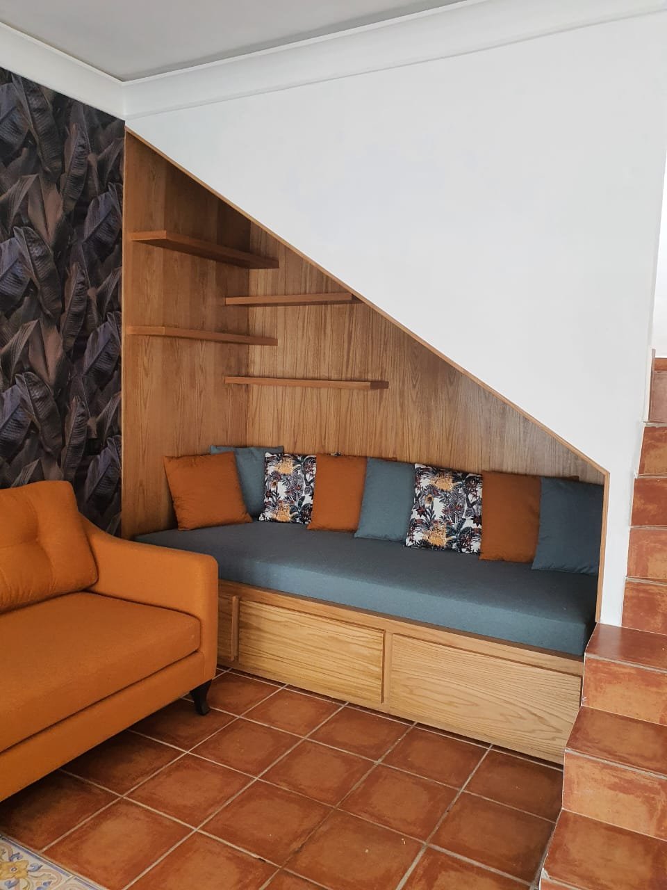 Banquette et étagères sur mesure aménagées sous un escalier