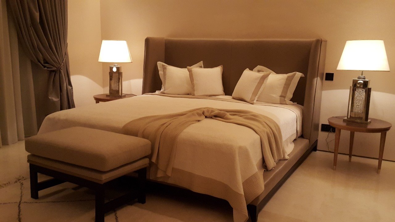 Suite parentale beige avec tête de lit capitonnée et bout de lit