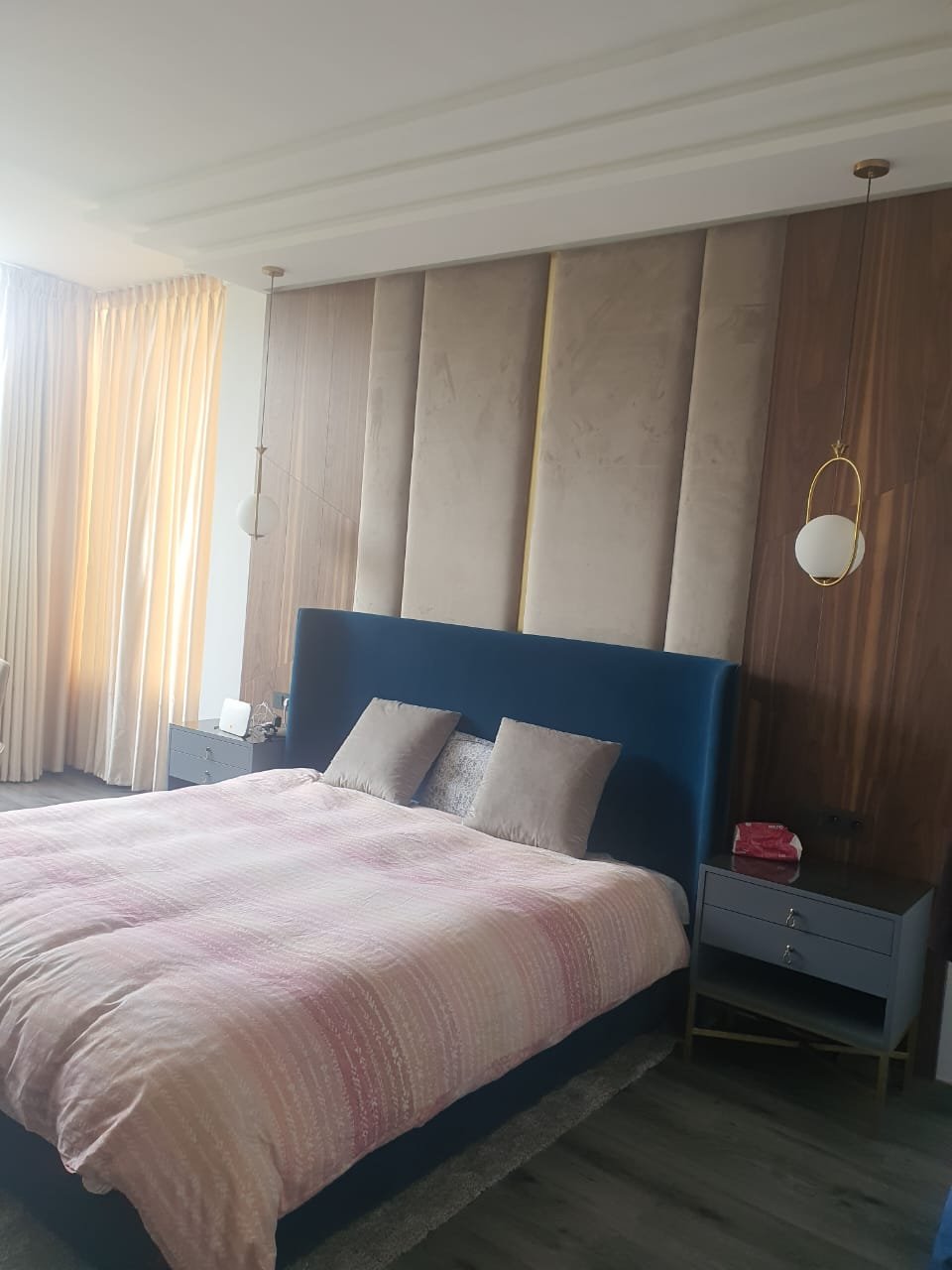Chambre avec tête de lit bleue et panneaux muraux capitonnés