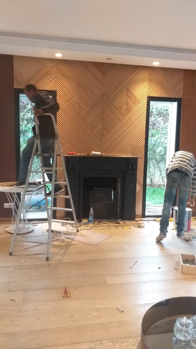 Pose d'un lambris en chevrons autour d'une cheminée, en chantier