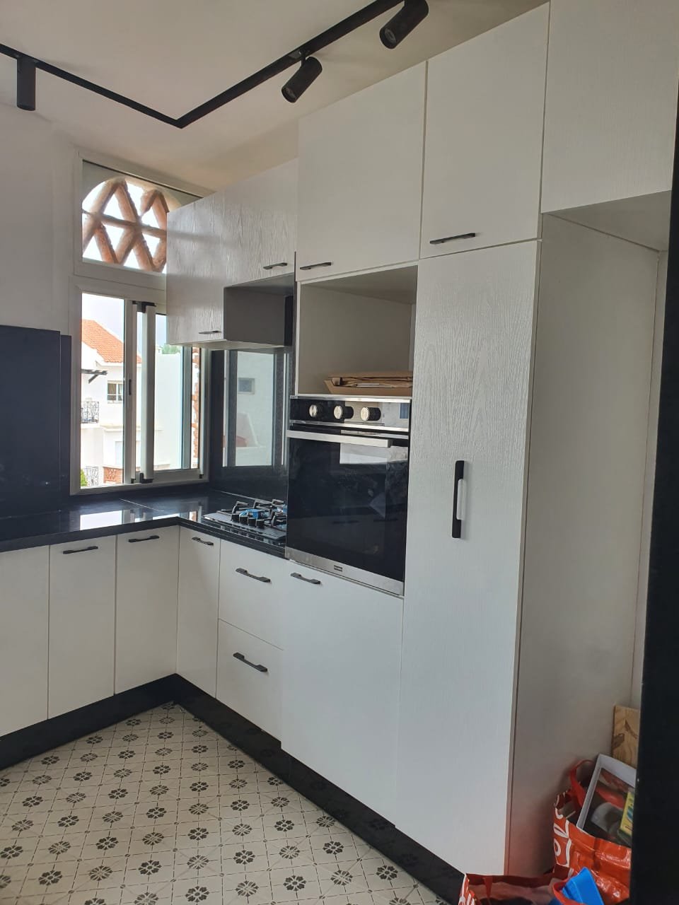 Cuisine blanche et noire avec sol en carreaux de ciment