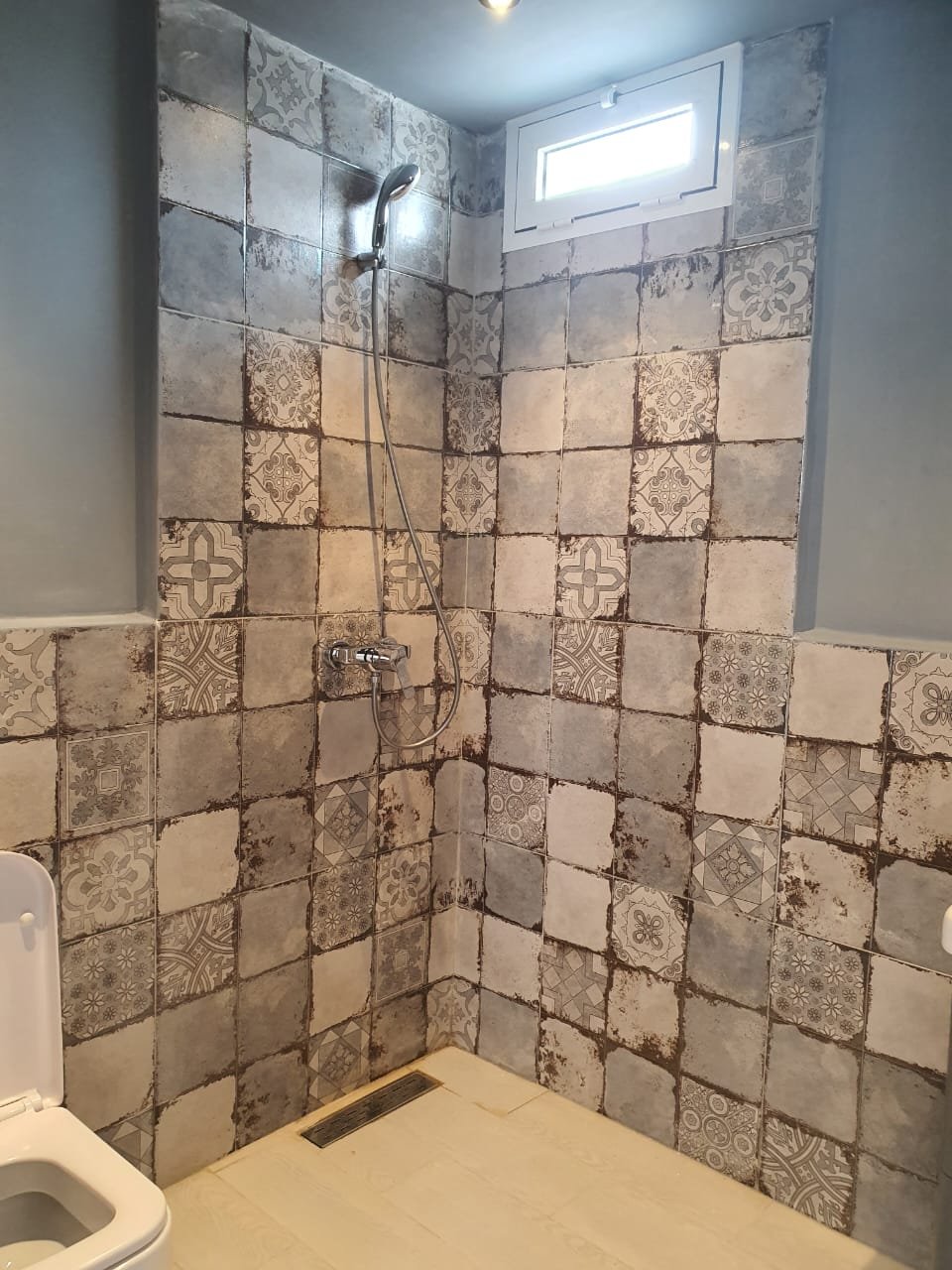 Douche à l'italienne habillée de carreaux de ciment à motifs