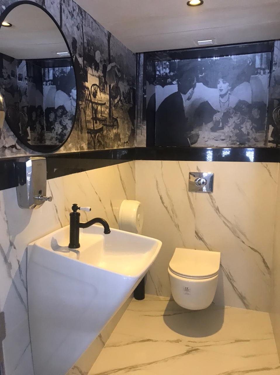 Salle d'eau en marbre avec vasque suspendue et fresque photographique