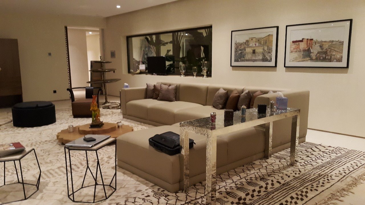 Double séjour beige avec canapés modulaires et grand tapis berbère