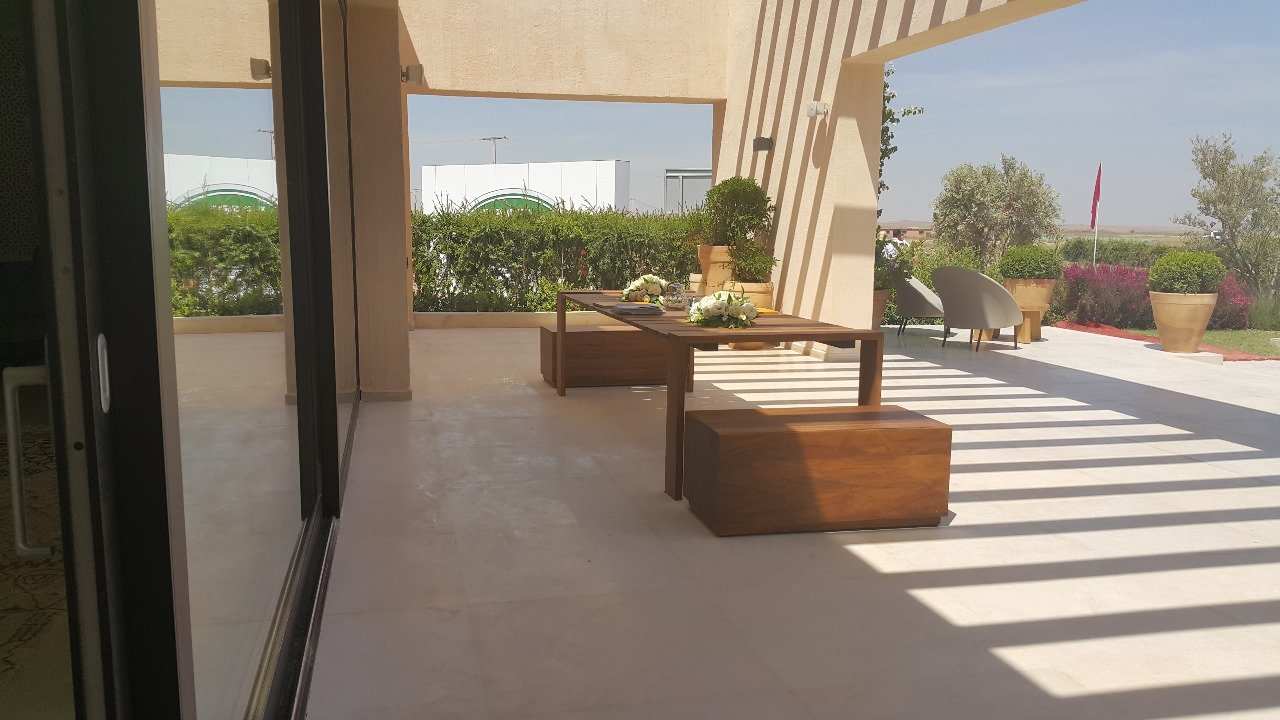 Terrasse couverte d'une villa ouverte sur le jardin